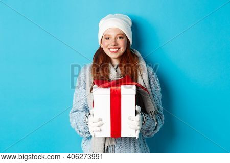 Winter Holidays And Christmas Sales Concept. Cute Redhead Teeanage Girl In Beanie, Sewater And Scarf