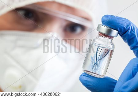 Female Nhs Microbiologist Or Lab Biotechnician Holding Glass Bottle Vial With Dna Helix Strand Float