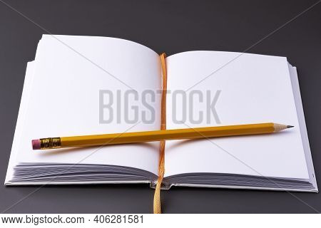 An Open Notebook With A Pencil On A Dark