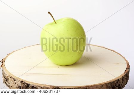 Green Apple On A Wooden Stand On A White Background