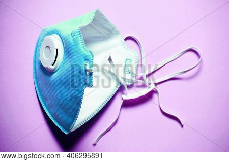 Blue Face Filter Mask On The Purple Table Surface. Viruses. Protection, Healthcare And Medicine