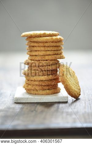 Heap of stacked, golden brown buscuits. Delicious and crispy coconut cookies on white background.