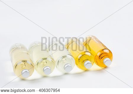 Collection Transparent Lying Bottles With Different Pale Colors Liquid, Cosmetic Product, Perfume Or