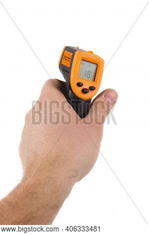 A Man Holds A Yellow-black Pyrometer. A Device For Non-contact Temperature Measurement. Studio Photo