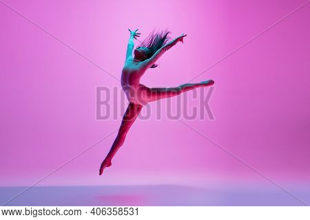 Flying, Freedom. Young And Graceful Ballet Dancer On Pink Studio Background In Neon Light. Art, Moti