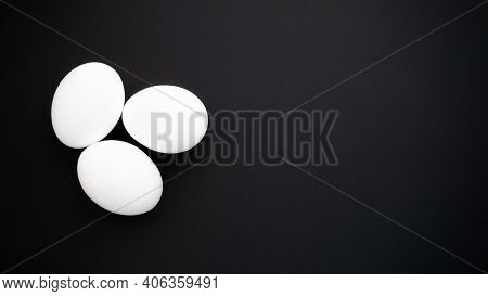 Group Of Chicken Eggs On A Dark Black Smooth Surface. Healthy Breakfast Of Boiled Protein Products.