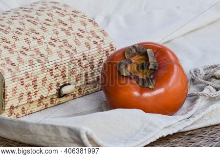 Persimmon Fruit On Black Plate With Woven Bamboo Type Background . Fresh Organic Produce Farm Fresh 