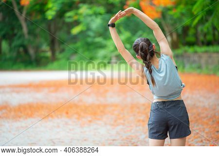 Back View Of Runner Woman Doing Stretching And Warming Up Her Body Before Running. The Benifit Of St