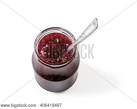 Spoon In Open Jar Full Of Delicious Sweet Raspberry Jam Isolated On White Background. Traditional Ho
