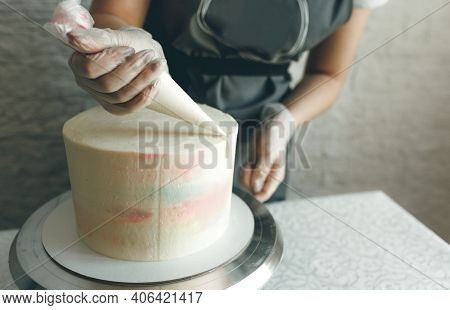 A Pastry Chef Girl Makes A Wedding Cake With Her Own Hands And Squeezes The Cream On The Layers Of T