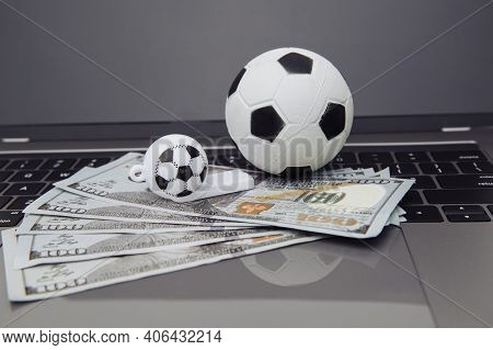 Soccer Whistle And Ball With Dollar Banknotes On Laptop. Betting On Sport Online Concept