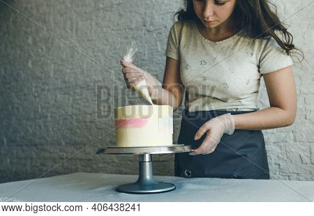 A Pastry Chef Girl Makes A Wedding Cake With Her Own Hands And Squeezes The Cream On The Layers Of T