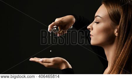 Side View. Portrait Of Young Pretty Woman Pouring Dropping Hair Cosmetics To Hand For Making Hairsty