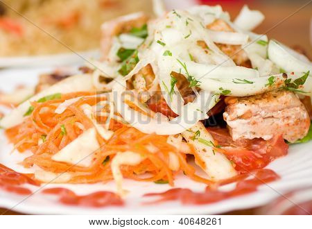 Appetizing weal kebab on skewers with greens