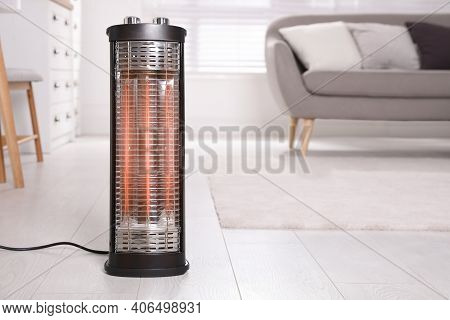 Modern Electric Heater On Floor At Home. Space For Text