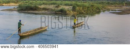 Chitwan, Nepal - November 09, 2019: Nepalese Men In Wooden Canoes On The River In Sauraha, Nepal