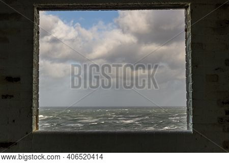 Window Frame In Derelict Building Looking Out To Stormy Sea.