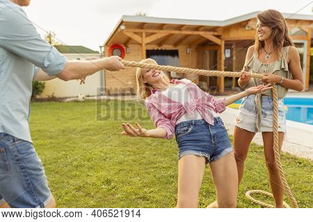Group Of Cheerful Young Friends Having Fun At Summertime Outdoor Party By The Swimming Pool, Partici