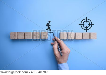 Male Bussinnes Man Hand Drawing A Connecting Line Between Two Sets Of Wooden Blocks For A Silhouette