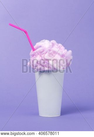 Conceptual image of milkshake with pink foam on viiolet background