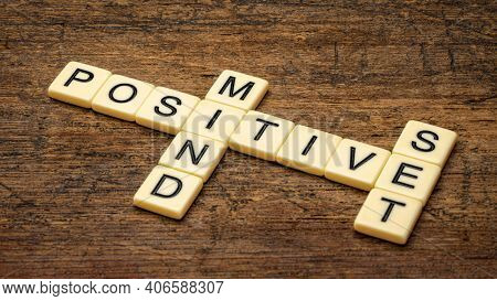 positive mindset crossword in ivory letter tiles against rustic wood, positivity, lifestyle and personal development concept