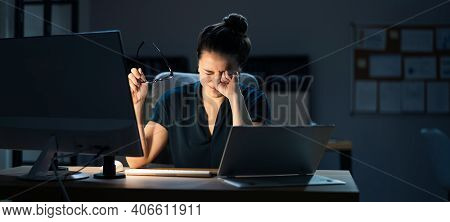 Woman With Dry Tired Eyes Working Late At Night Using Computer In Office