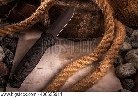 The Reverse Side Of The Knife With A Clip On The Background Of Stones And Rope. Photo Of A Knife Wit