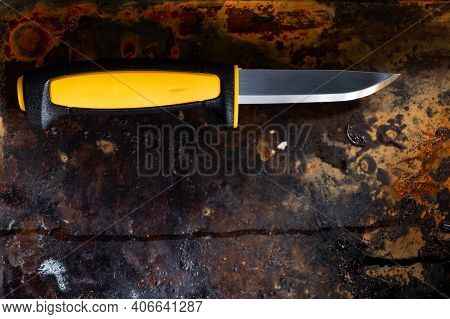 Fixed Blade Knife. Knife With A Yellow Handle. Knife On A Rusty Background.