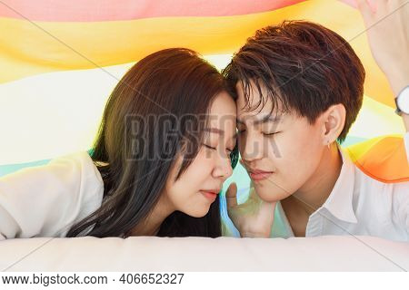 Lgbtq Couple Lovers, A Handsome Girl As A Man Or Butch Femme Covered 
With The Rainbow Flag The Symb