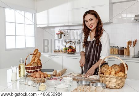 Asian Middle-aged Woman Kneading Dough For Baking Happy And Smile In The Home Kitchen. Concept Desse