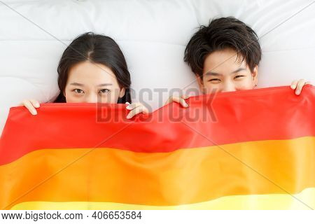 Lgbtq Couple Lovers, A Handsome Girl As A Man Or Butch Femme Girl Laying On A Bed With The Rainbow F
