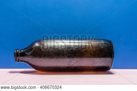 Old Edible Oil Storage Glass Bottle On Blue Background