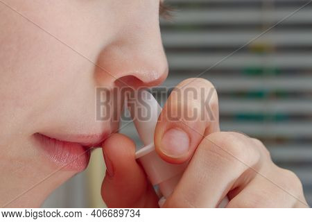 A Child Treats A Runny Nose With A Nasal Spray From Snot