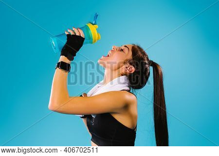 A Girl With Great Thirst After A Workout With A Towel Around Her Neck, Take A Break And Drinks Pure 