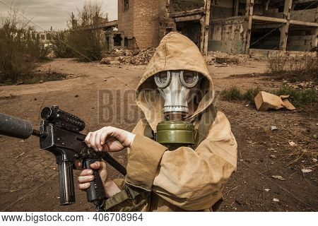 Boy Stands With A Gun In His Hand. Boy In A Gas Mask. \ra Young Man In A Protective Cloak And Hood. 