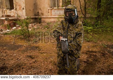 Boy Stands With A Gun In His Hand. Boy In A Gas Mask. \\ra Young Man In A Protective Cloak And Hood.