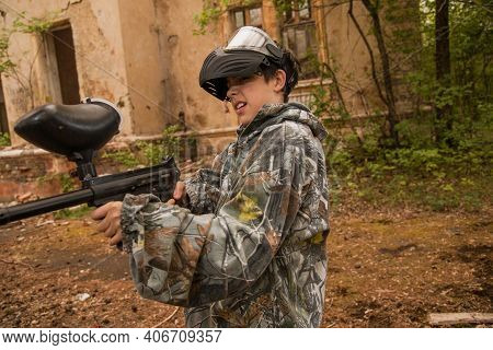 Boy Stands With A Gun In His Hand. Boy In A Gas Mask. \\ra Young Man In A Protective Cloak And Hood.