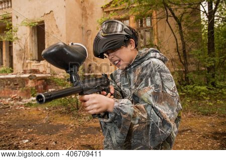Boy Stands With A Gun In His Hand. Boy In A Gas Mask. \\ra Young Man In A Protective Cloak And Hood.