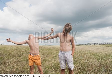Boys Standing In A Field . Boys In Shorts.   Two Friends. Children Playing In The Field.