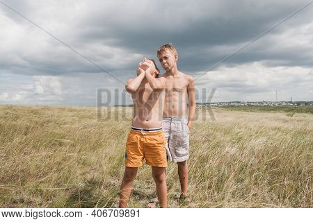 Boys Standing In A Field . Boys In Shorts.   Two Friends. Children Playing In The Field.