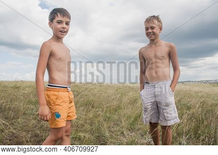 Boys Standing In A Field . Boys In Shorts.   Two Friends. Children Playing In The Field.