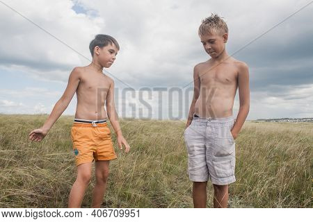 Boys Standing In A Field . Boys In Shorts.   Two Friends. Children Playing In The Field.