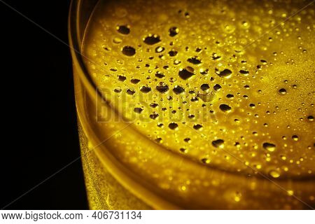 Glass Of Beer Seen Up Close With Black Background.
