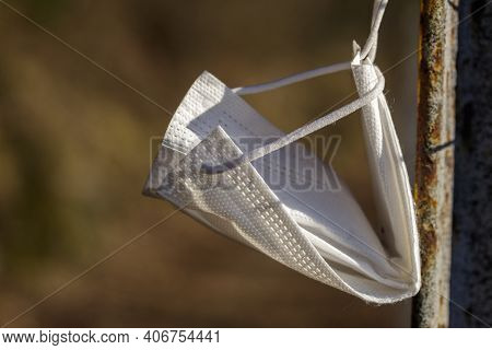 Surgical Mask Abandoned On A Mountain Path And Hung On A Pole By A Passer-by.