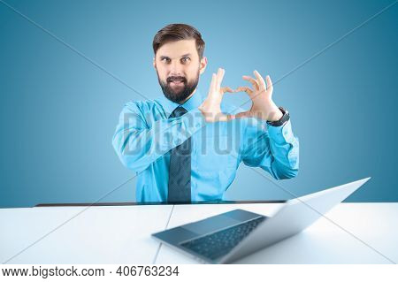 A Bearded Businessman At A Laptop Shows His Heart With His Fingers, A Man In A Shirt And Tie Shows T