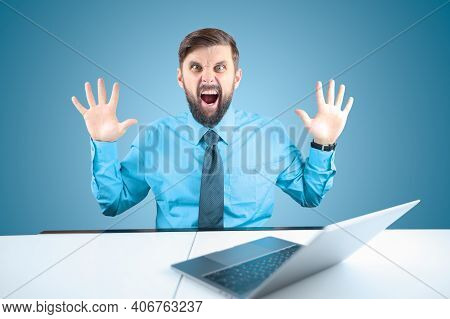 A Bearded Businessman Behind A Laptop Holds Out His Hands And Shouts, A Man In A Blue Shirt Shows Th