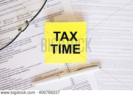 Yellow Sticker With Text Tax Time On Financial Docs. Notepad, Eyeglasses And White Pen