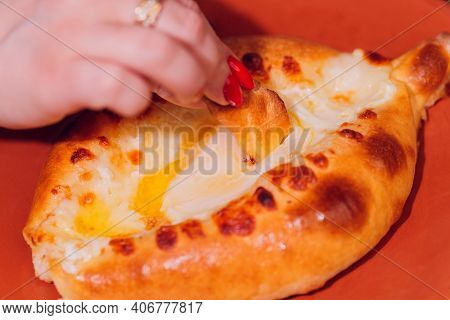 Woman Is Eating Adjarian Khachapuri With Hands, Crushing Egg Yolk.