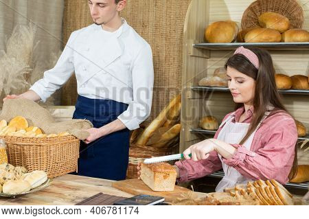 Before The Arrival Of Customers, The Baker Corrects The Arrangement Of The Bread And The Young Sales