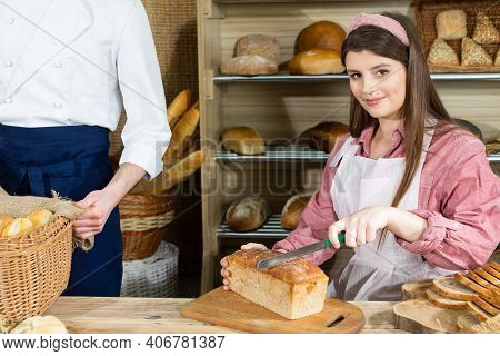Before The Arrival Of Customers, The Baker Corrects The Arrangement Of The Bread And The Young Sales